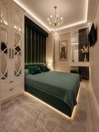 a bedroom with a green bed and a chandelier at Luxanda Plaza in Samarkand