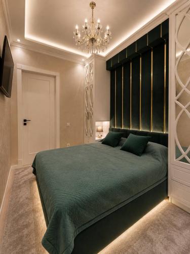 a bedroom with a large green bed with a chandelier at Luxanda Plaza in Samarkand