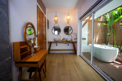 a bathroom with a tub and a sink and a mirror at Villa Vara - Tropical Pool Villa in Ao Nang Beach