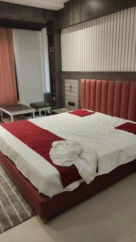a bedroom with a large bed with a red headboard at Hotel bindu in Ghāzīpur