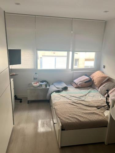 a bedroom with a bed and a desk and window at Steve's Condo in Davao City