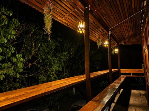 a wooden bench on a porch at night at Thanomrak homestay in Ban Pha Saeng Lang