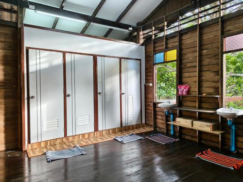 a bathroom with two sinks in a room with wooden walls at Thanomrak homestay in Ban Pha Saeng Lang