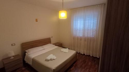 a bedroom with a bed with two towels on it at Casa FerGi in Amandola