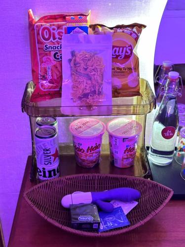 a shelf with some food and some cups of food at Đào Hoa Mộng Couple Hotel - Central & City View in Quy Nhon