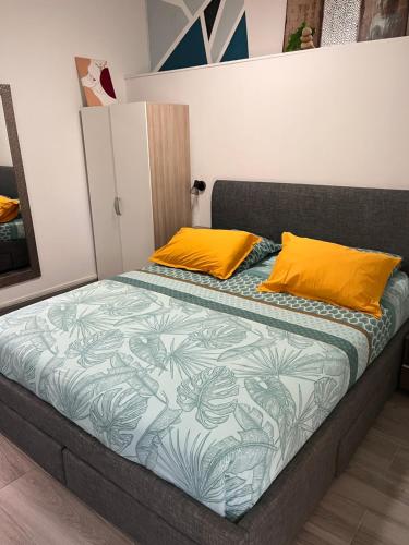 a bed with two orange pillows in a room at Chez Permal in Saint-Pierre