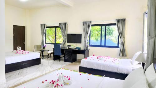 a bedroom with two beds and a desk with a computer at Sun resort & villa beach in Tiến Thành