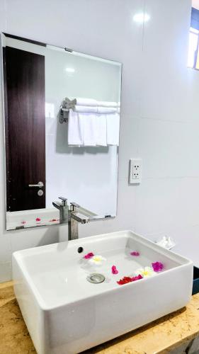 a white bath tub with flowers in it in a bathroom at Sun resort & villa beach in Tiến Thành