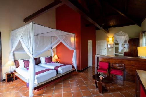 a bedroom with a bed with a canopy at Victoria Nui Sam Lodge in Chau Doc