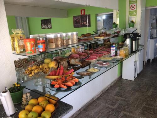 una línea de buffet con muchos platos de comida en Pousada Realiza, en Cambuquira