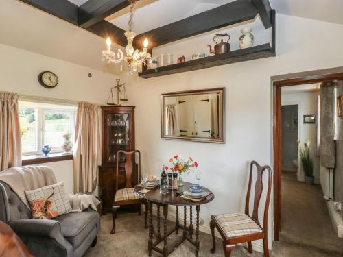 a living room with a table and a chair at Prospect Cottage in Sowerby Bridge