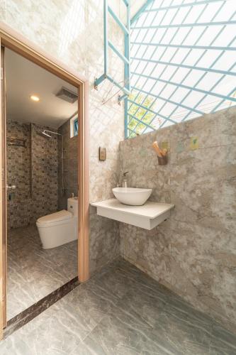 a bathroom with a sink and a toilet at Lazy Bear Villa By The Little Hoi An in Hoi An