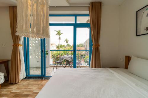 a bedroom with a bed and a large window at Lazy Bear Villa By The Little Hoi An in Hoi An