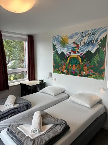 a room with three beds and a painting on the wall at Auberge de Jeunesse de La Roche - Champlon in Tenneville