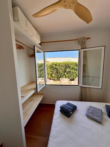 a room with a bed and a large window at Villa Gabriela in S'Algar
