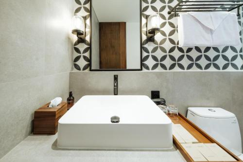 a bathroom with a white sink and a toilet at Nuho Living in Bingin Beach