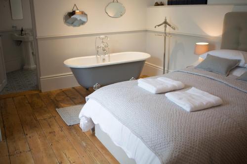 a bedroom with a bed and a bath tub at Little Boutique Club in Bridport