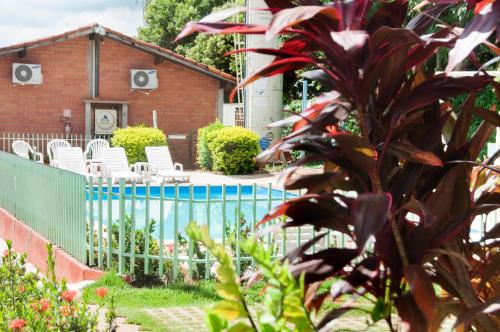 a house with a fence and chairs in a yard at Bonito HI Hostel e Pousada in Bonito