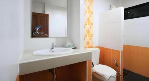 a bathroom with a white sink and a toilet at Phakawan Hotel in Ban Nong Chik