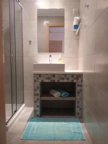 La salle de bains est pourvue d'un lavabo et d'une douche. dans l'établissement Superior Savvas Apartments by the sea, à Agia Pelagia