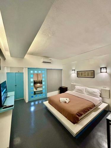 a bedroom with a large bed and a desk at At The Pad Hotel & Villa's in Angeles