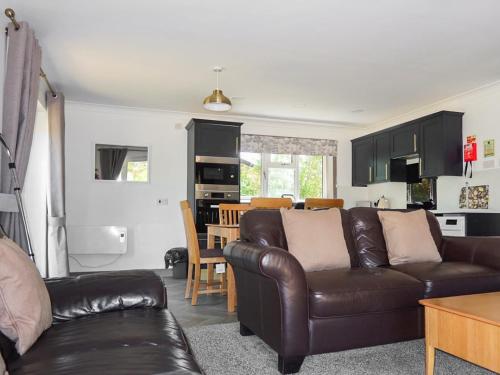 a living room with a leather couch and a kitchen at Mallard - Uk41033 in Marston