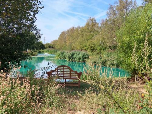 a park bench sitting in front of a river at Mallard - Uk41033 in Marston