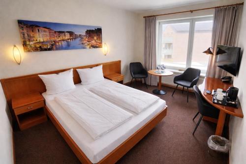 a hotel room with a bed and a table and chairs at Hotel Adler & Eventlocation GmbH in Itzehoe