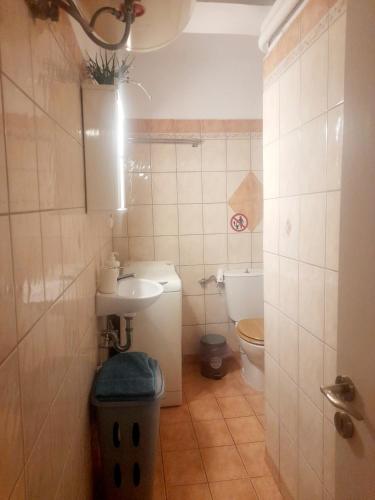 a small bathroom with a sink and a toilet at Cozy apartment in Piraeus