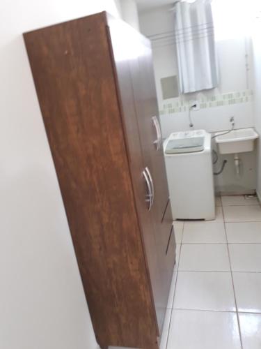 a bathroom with a toilet and a sink and a wooden door at Flats Di Cavalcanti in Uberlândia