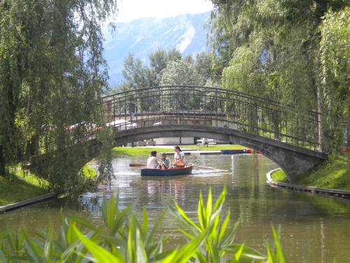 a group of people in a boat on a river under a bridge at Flackl - Wirt in Reichenau