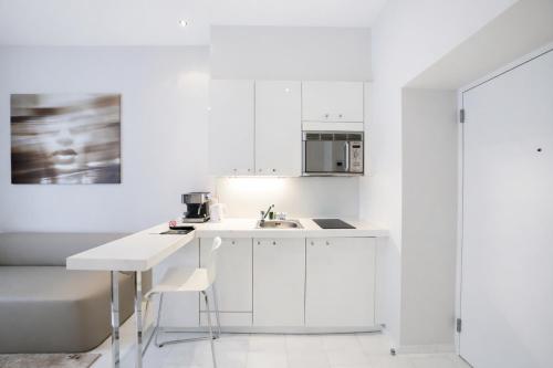 a white kitchen with a sink and a microwave at VISIONAPARTMENTS Gerechtigkeitsgasse - self check-in in Zurich