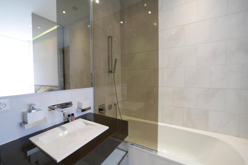 a bathroom with a sink and a shower at VISIONAPARTMENTS Gerechtigkeitsgasse - self check-in in Zurich