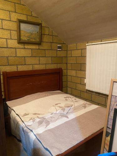 a bed in a room with a brick wall at Lavanda City in Sevan