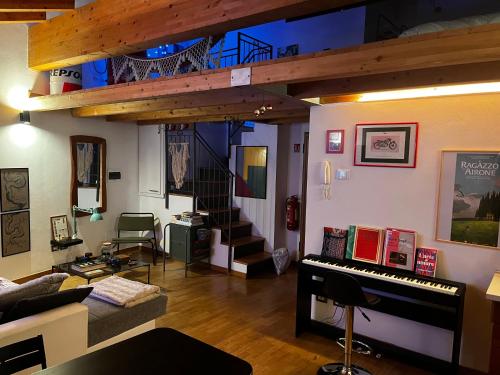 a living room with a staircase and a piano at Casa di Leo in Morbegno