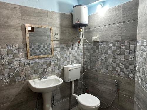 a bathroom with a sink and a toilet and a mirror at Hill Ice Guesthouse & Cafe - Mountain View & Balcony, Tosh in Tosh