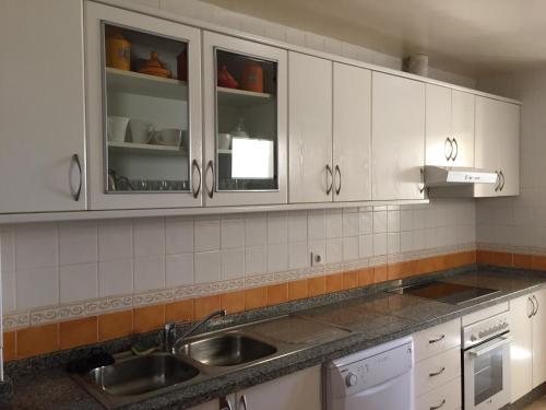 a kitchen with white cabinets and a sink at Appartement Saidia Méditerranée in Saidia 