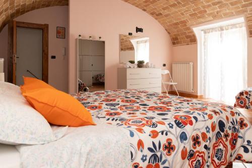 a bedroom with a large bed with an orange pillow at La Rusacca Pacentro in Pacentro