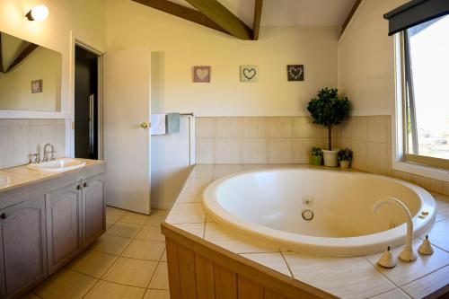 a large bathroom with a tub and a sink at Alpzview Guesthouse in Tawonga