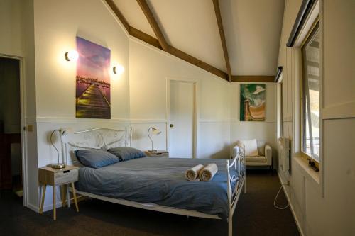 a bedroom with a bed with a blue comforter at Alpzview Guesthouse in Tawonga
