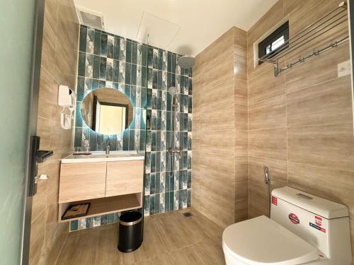 a bathroom with a toilet and a sink and a mirror at Cham Charm Apartment Hotel Mui Ne in Mui Ne