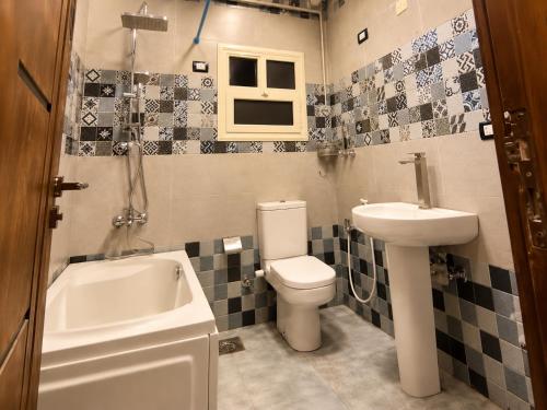 a bathroom with a toilet and a sink and a tub at בית ההר - וילה למשפחות עם בריכה פרטית in Rama