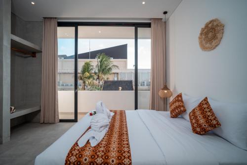 a bedroom with a bed and a large window at Snuggy Shack Villas in Munggu