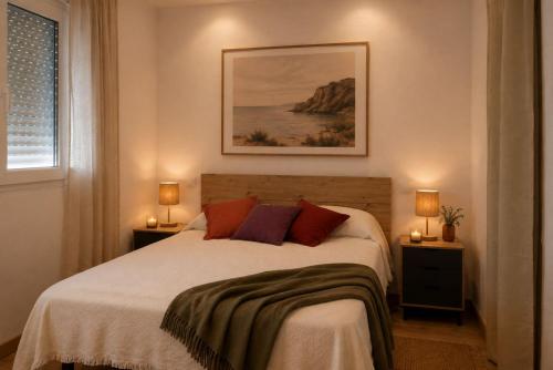 a bedroom with a bed with two lamps and a window at CocoHills in Monte Pego