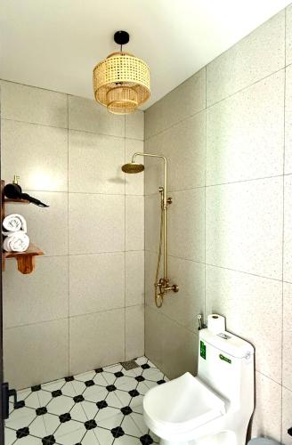 a bathroom with a toilet and a chandelier at An Bang Chic Villa Nguyên Căn in Tân Thành (1)