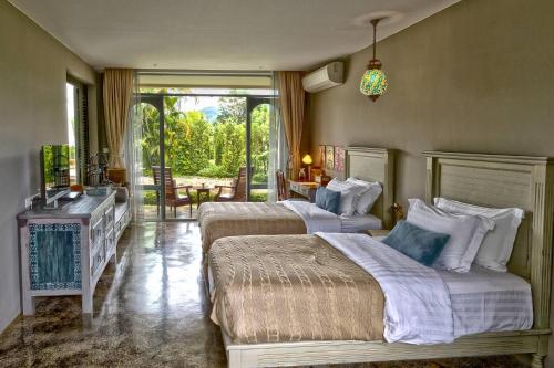 a hotel room with two beds and a window at Reverie Siam in Pai