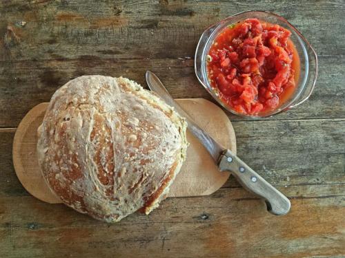 a loaf of bread on a table with a bowl of salsa at Olympos Koyevi Pension in Olympos