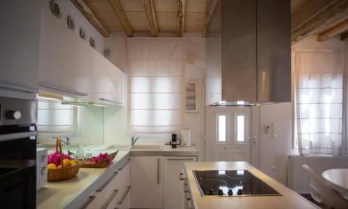 a white kitchen with a sink and a counter top at Mykonian Style w Shared Pool Houses 8 & 9 in Ornos