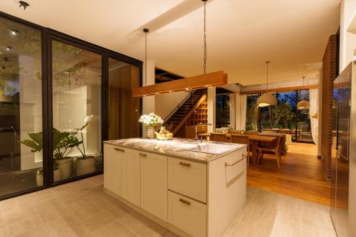 an open kitchen with a dining room and a house at Villa Pakuk by Alfred in Bali in Canggu