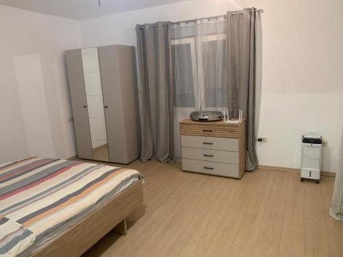 a bedroom with a bed and a dresser and a window at Amor in Klake
